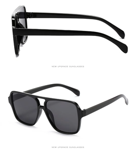 Detail view of black double-bridge aviator sunglasses with glossy finish and dark lenses