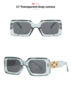 Detail view of transparent grey square sunglasses with decorative gold metal hinges