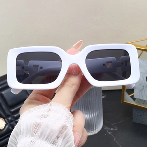 Detail of white rectangle sunglasses with chunky frames and hollow chain temple design