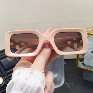 Close-up of rectangular thick frame sunglasses in soft cream with gradient lenses