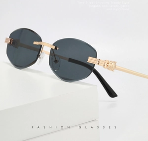 Detail of luxury sunglasses with leopard head metal gold temple and dark rimless lens