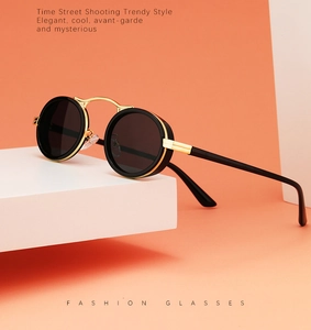 Detail shot of steampunk sunglasses with retro oval black lenses and gold bridge