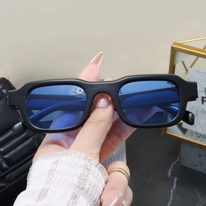 Detail of square vintage sunglasses with black frames and translucent blue lenses