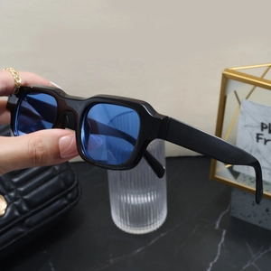 Detail of square vintage sunglasses with black glossy frames and transparent blue lenses