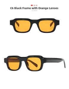 Detail view of square black frame sunglasses with vibrant orange lenses and thick temples