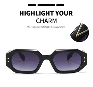 Detail of polygonal black sunglasses with purple gradient lenses and gold V decoration