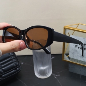Detail showing thick black frames and translucent brown lenses of vintage sunglasses