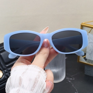 Close-up of retro light blue thick oval frame sunglasses with dark UV protective lenses