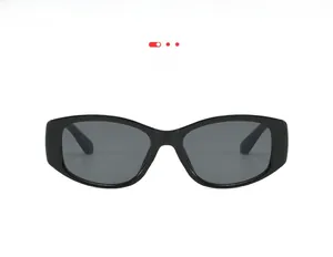 Close-up of retro black oval sunglasses with glossy resin frame and dark tinted lenses