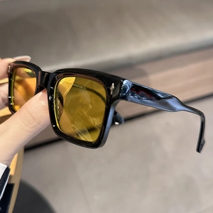 Primo piano di occhiali da sole squadrati retrò con montatura nera e lenti color ambra