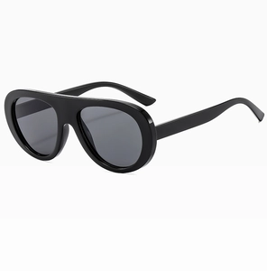 Detail view of bold black oversized oval sunglasses with sleek glossy finish