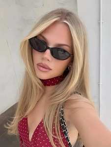 Primo piano di una donna bionda con occhiali da sole ovali neri dal design rétro chic