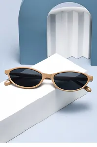 Occhiali da sole ovali retro minimalisti con montatura kaki su sfondo blu di design