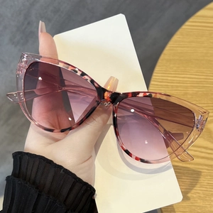 Detail der rosa Cat-Eye-Sonnenbrille mit Schildpattmuster und lila Verlaufsgläsern