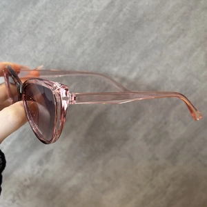 Detailansicht der rosa transparenten Katzenaugen-Brille mit grauem Verlaufsglas-Effekt