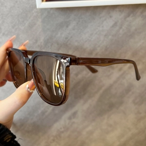 Detail view of transparent brown sunglasses frame with silver star metal rivets