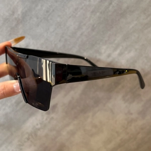 Vue latérale de lunettes de soleil sans monture à écran unique et branches larges