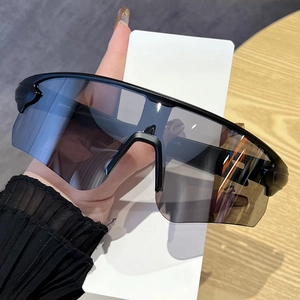 Détail de lunettes de cyclisme avec verres dégradés gris et monture noire surdimensionnée