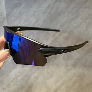 Détail de lunettes de cyclisme noir mat avec verres miroir bleus et fentes de ventilation