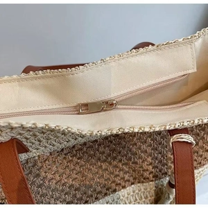Detail of woven straw beach bag with a secure metal zipper and durable canvas lining