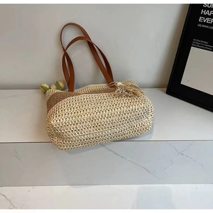 Detail of color-block straw tote bag with fringe tassels on white marble stairs