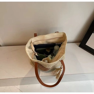 Detailed interior of woven straw tote bag showing spacious capacity and leather handles
