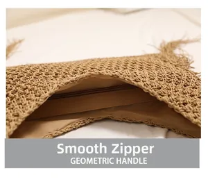 Detailed view of the smooth zipper closure on the straw woven beach shoulder bag