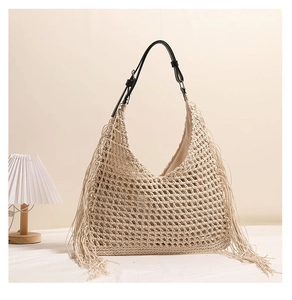 Detail of hollow woven straw bag with long fringe and adjustable black leather strap