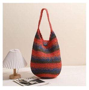 Detail of crochet striped tote bag with red and blue woven texture and broad strap