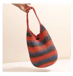Close-up of colorful striped straw shoulder bag with handmade crochet texture details