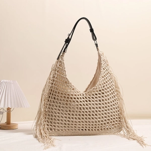 Bohemian style straw shoulder bag with tassels and black leather adjustable strap