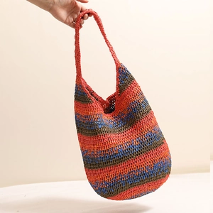 Colorful striped woven straw shoulder bag in orange and blue for beach vacations