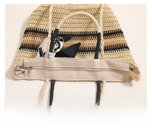Détail de la fermeture éclair fluide et des anses tissées sur un sac cabas en paille rayé