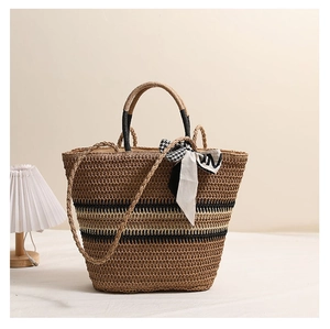 Détail du sac cabas en paille rayé avec anses rondes et foulard en soie élégant noué