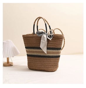 Détail d'un sac en paille tressée avec rayures noires et blanches et foulard en soie chic
