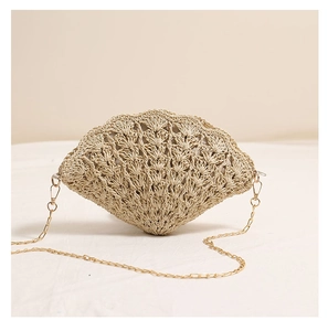 Close-up of beige shell-shaped straw bag with hollow-out crochet pattern and gold chain