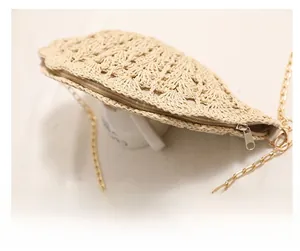 Detailed close-up of smooth metal zipper and hand-woven texture on shell straw bag