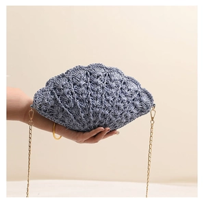 Close-up of a light blue shell-shaped woven bag with golden chain and knit texture