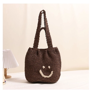 Close-up of woven cotton tote bag in dark coffee with an embroidered smiley face design