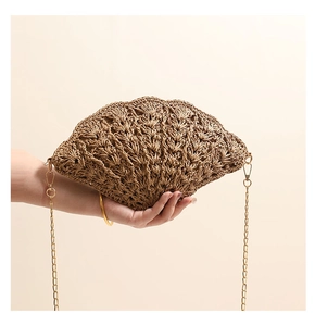 Detail of shell-shaped woven bag showing intricate crochet hollow pattern and gold metal chain