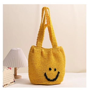Detailed view of yellow cotton woven shoulder bag with a black smiley face pattern