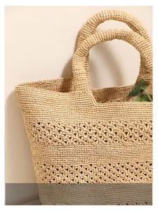 Detailed macro view of beige raffia tote bag showing hollow floral weaving patterns