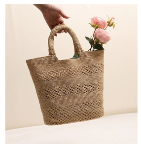 Detailed macro view of beige raffia tote bag showing three layers of hollow crochet patterns