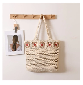 Détail du sac cabas beige au crochet avec broderies florales rouges et maille tissée