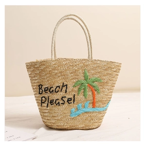 Dettaglio borsa da spiaggia in paglia con ricamo di palma e scritta Beach Please!