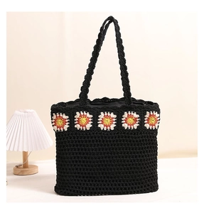 Détail d'un sac cabas noir crocheté à la main avec motifs de tournesols colorés