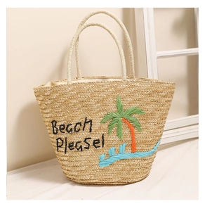 Dettaglio del ricamo a palma e scritta 'Beach Please!' sulla borsa di paglia