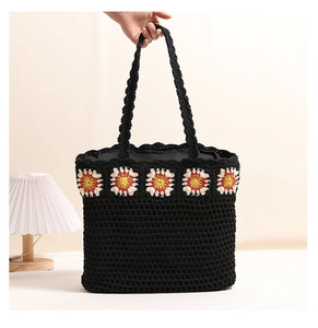 Détail du sac cabas en crochet noir avec motifs de marguerites colorées pour la plage