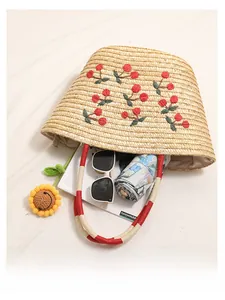 Straw tote bag with cherry embroidery and cotton rope handles showing spacious interior