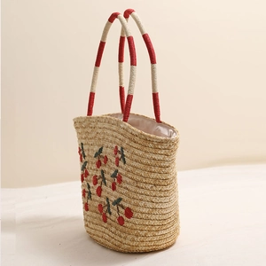 Handmade straw tote bag with red cherry embroidery and red braided handles for summer beach